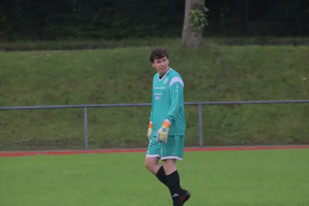 Torwart in grünem Trikot auf dem Platz