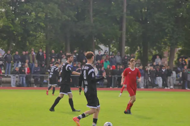 Spieler am Ball vor der Zuschauerkulisse