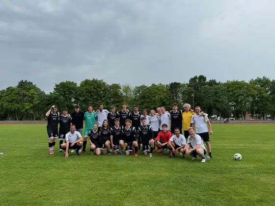 Gruppenbild beider Mannschaften auf dem Rasen