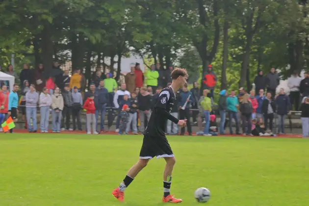 Spieler läuft mit dem Ball über den Platz